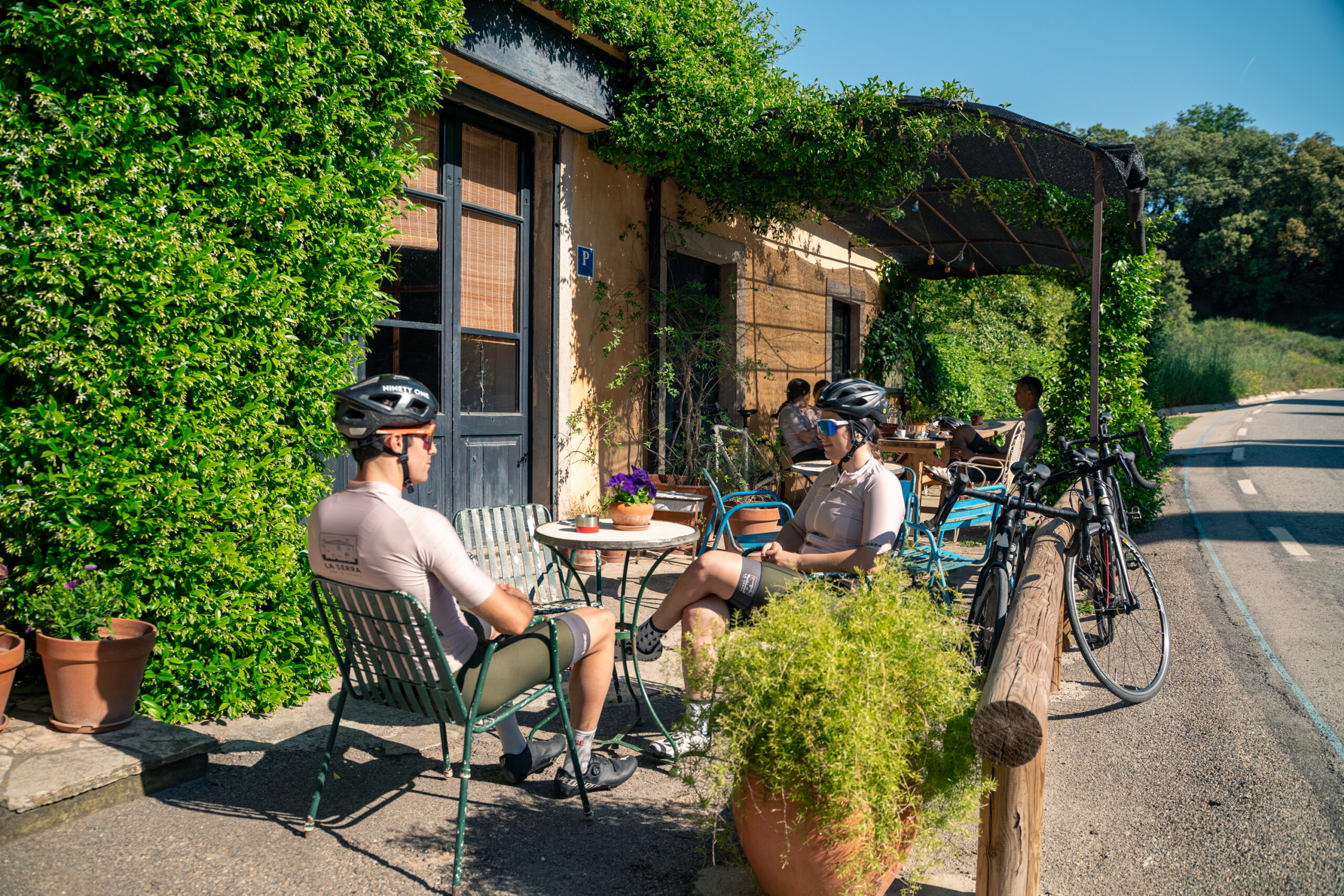 Ciclistes fent una pausa a la terrassa d’un establiment de carretera al Lluçanès